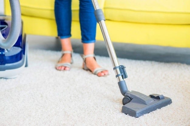 Woman vacuuming carpet