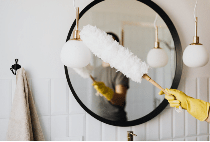 a person dusting a lamp