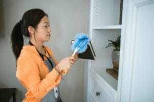 A cleaning lady service dusting in a house in Rockville.